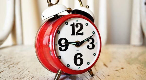 Red alarm clock sitting on a table