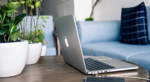 Laptop and cell phone sitting in living room on coffee table